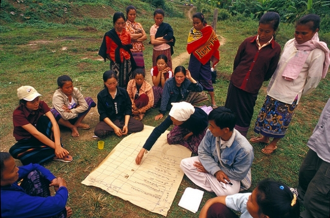 A Tribal woman in northern Laos votes her preference by piling Job’s tears next to the name of a rice variety. This mode of preference analysis voting allows participants to express the strength of their opinions by piling up many seeds,few or none. (Photo: Peter Fredenburg)