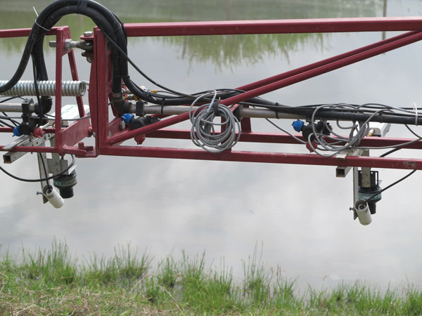 A GPS-guided field canopy sensor system mounted on a spray boom is used to measure some physical traits of rice plants. (Photo: IRRI