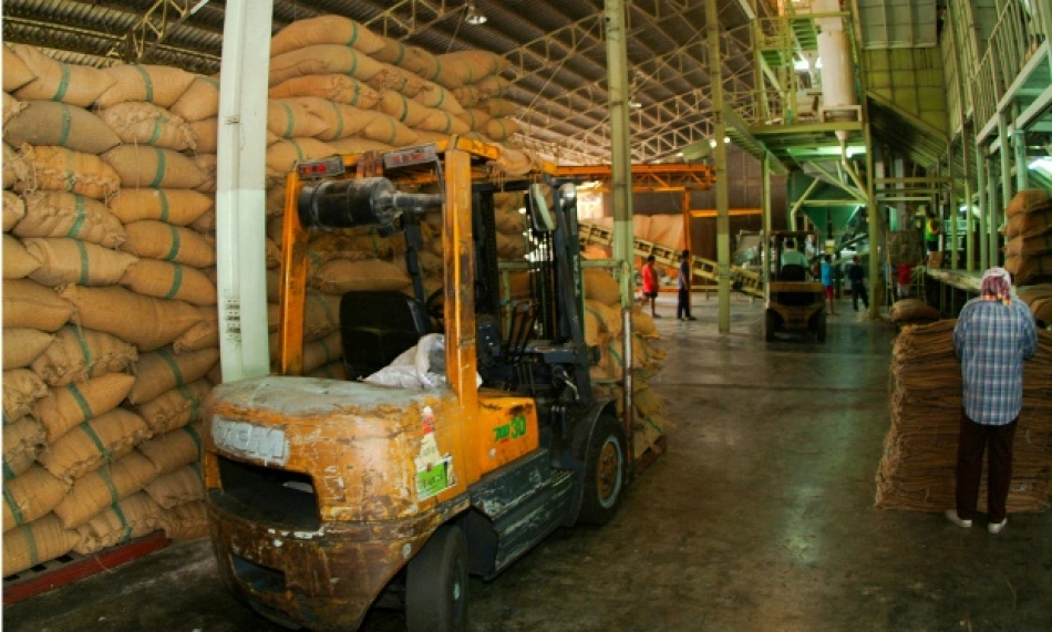 Piles of rice in jute sacks inside a rice mill in Thailand. (Photo: IRRI)