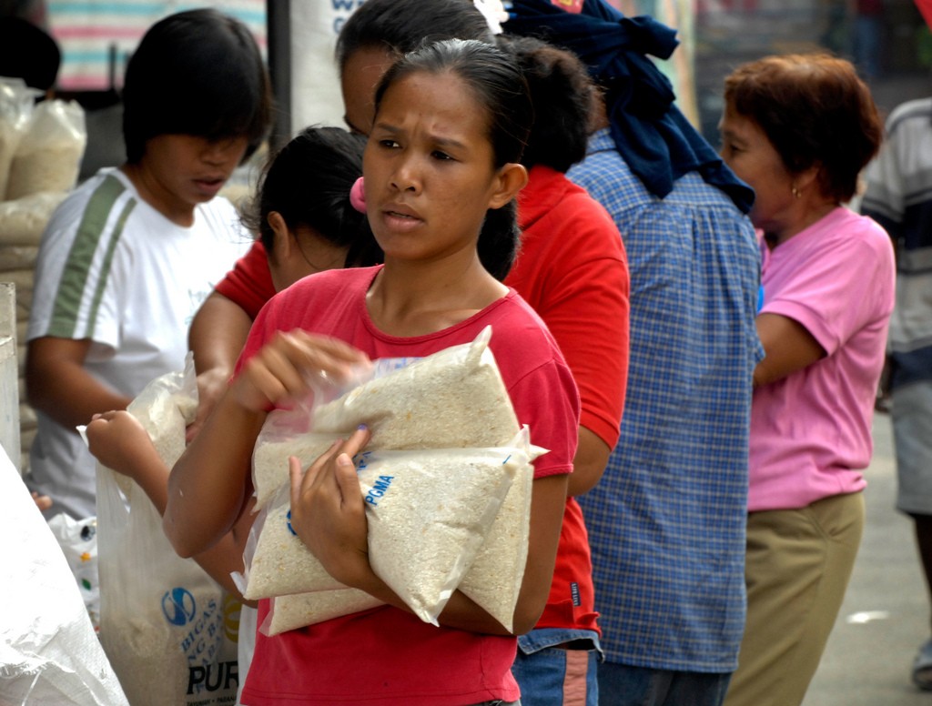 A Filipino woman collects subsidized rice at a market in Quezon City, Manila. High prices have hit the urban poor, many of whom spend a large proportion of their income on rice alone. (Photo: IRRI)