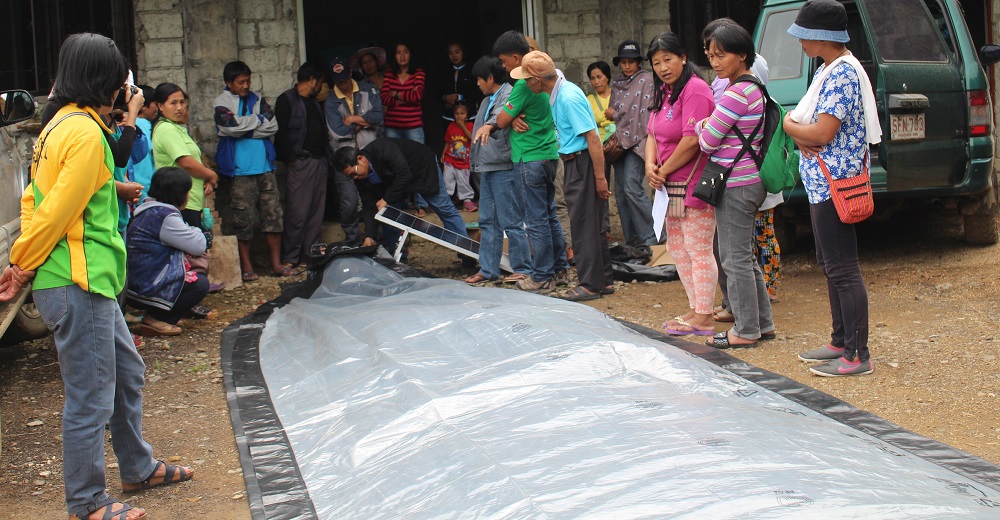 Setting up a solar-powered bubble dryer demo for heirloom rice farmers. The dryer is designed to dry agricultural commodities while protecting them from sudden rain and unpredictable weather. (Photo: IRRI)